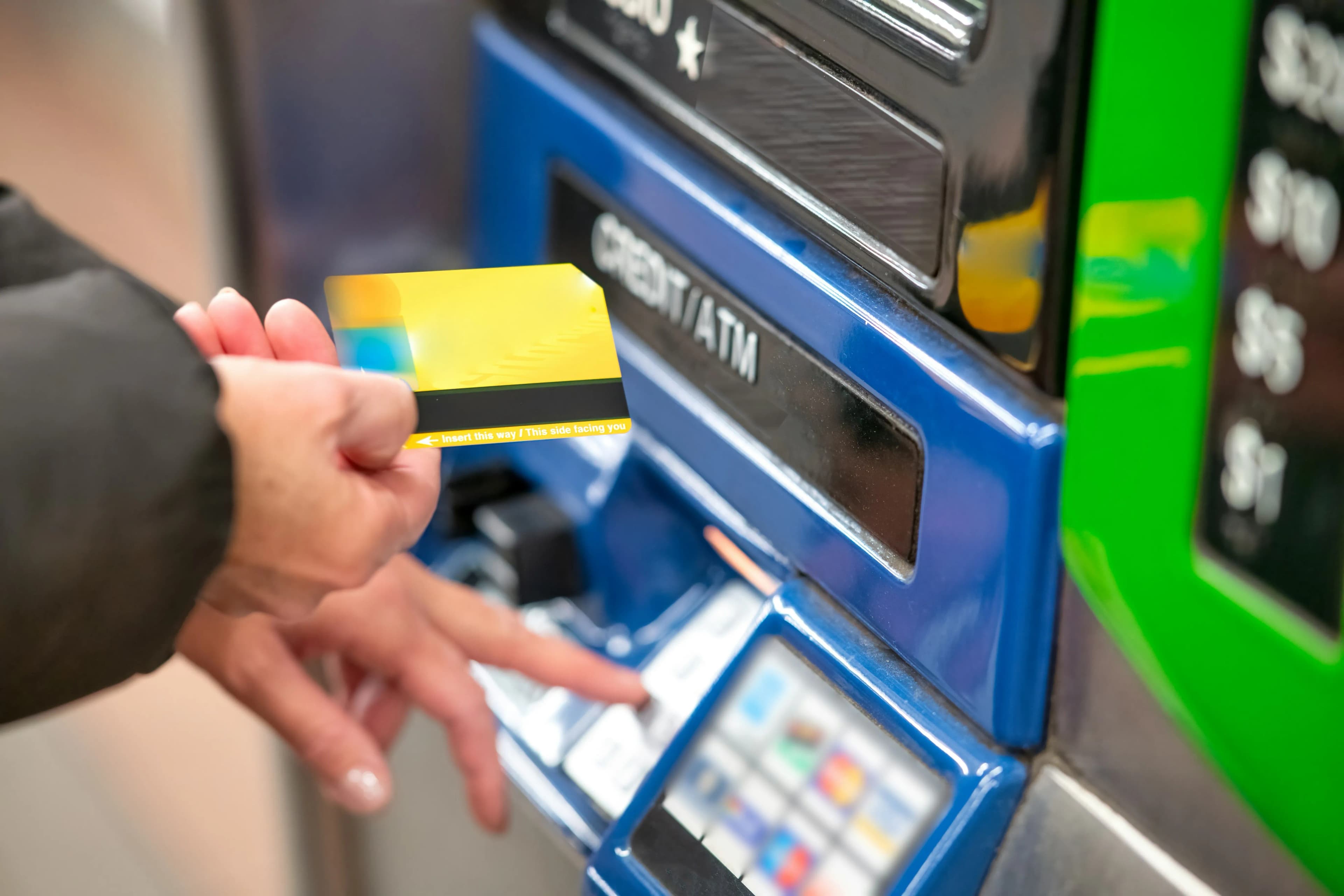 A bank card being inserted into an ATM card slot