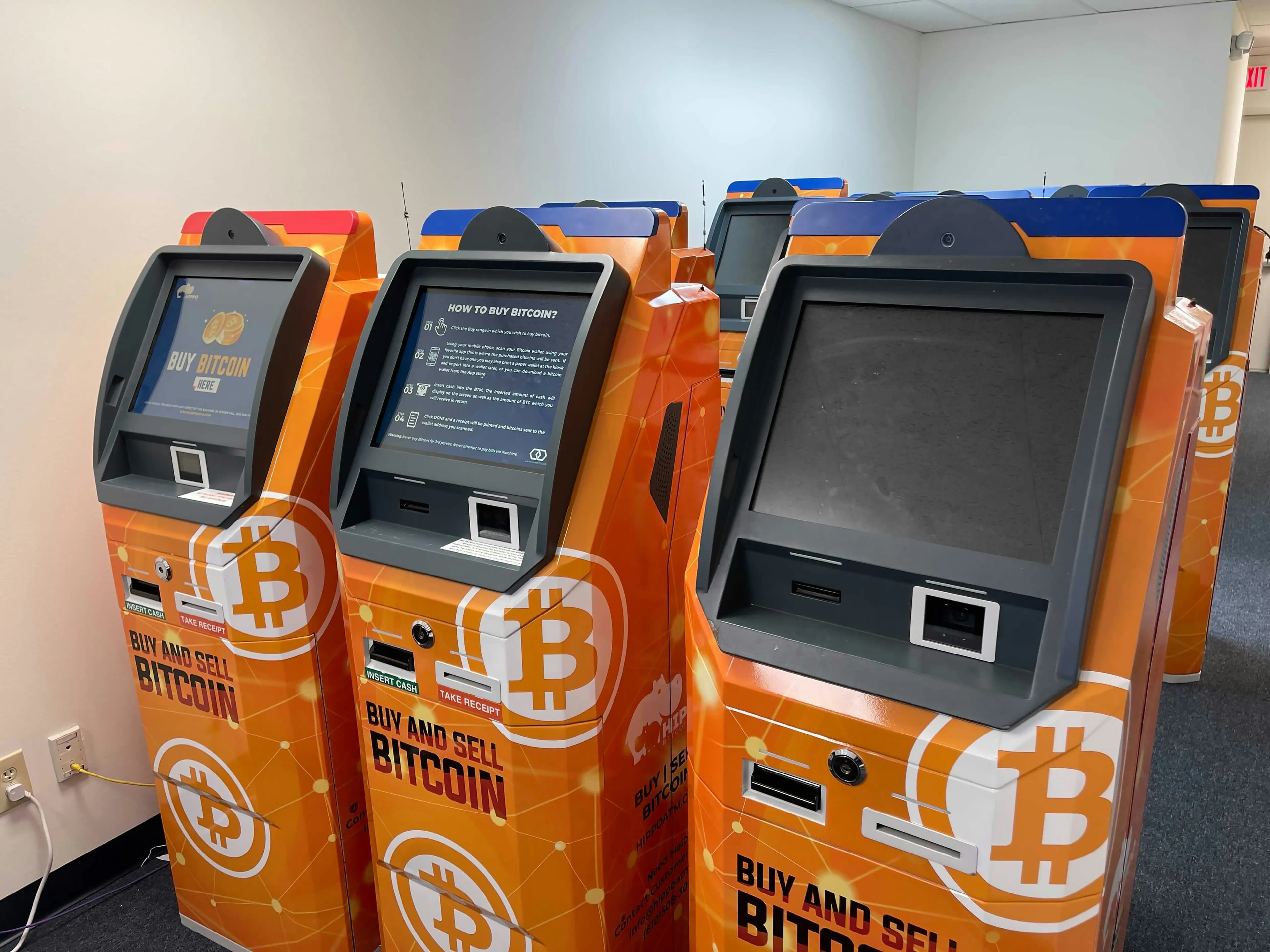 A row of orange cryptocurrency ATMs