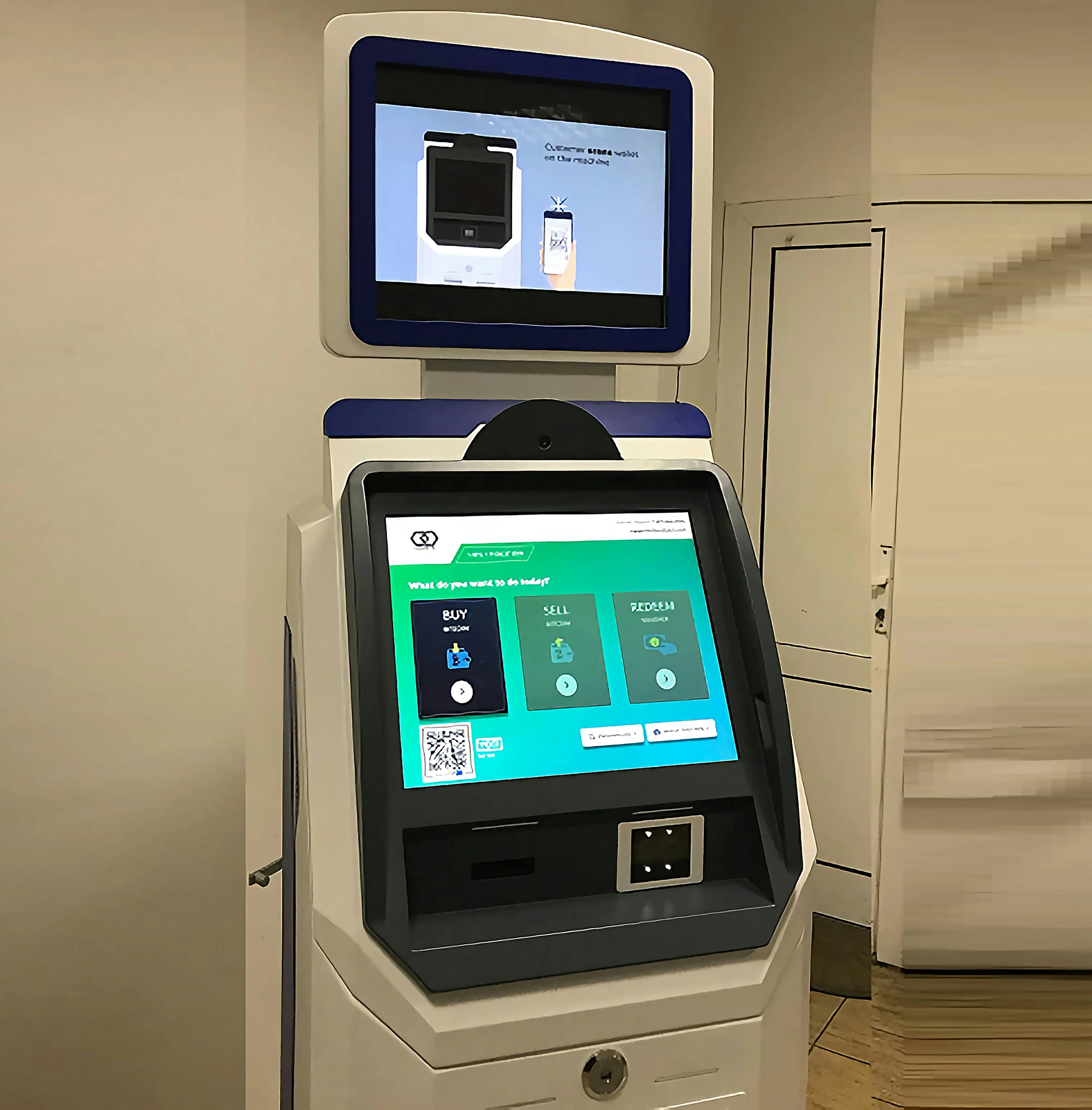 A modern touchscreen ATM standing in a hallway